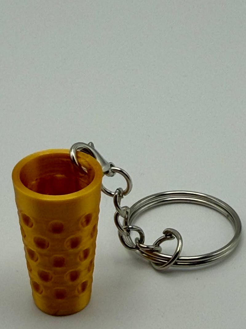Echte Makroaufnahme eines 3D-gedruckten Dubbeglas-Schlüsselanhängers mit sichtbaren Druckschichten