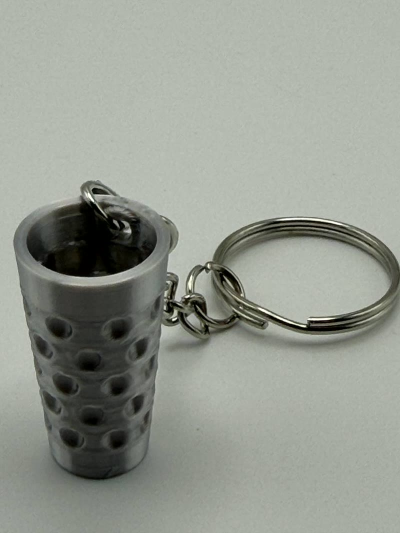 Echte Produktaufnahme eines silberfarbenen Dubbeglas-Schlüsselanhängers mit Kette und Schlüsselring